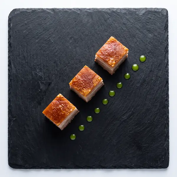 Cubes of lechon on board